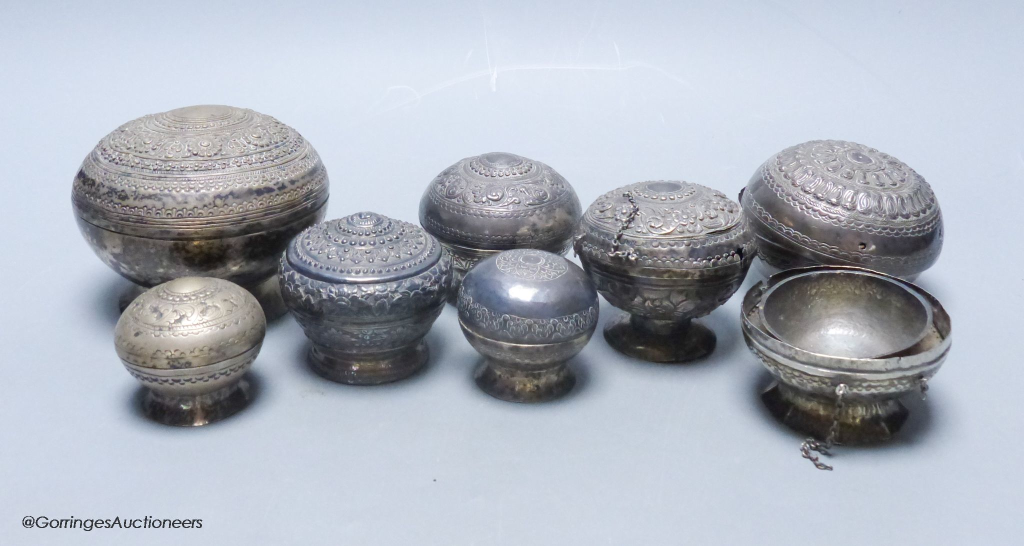 A collection of Malay Straits white metal circular betel nut boxes ('Chimbul'), Diameter 5cm to 10cm